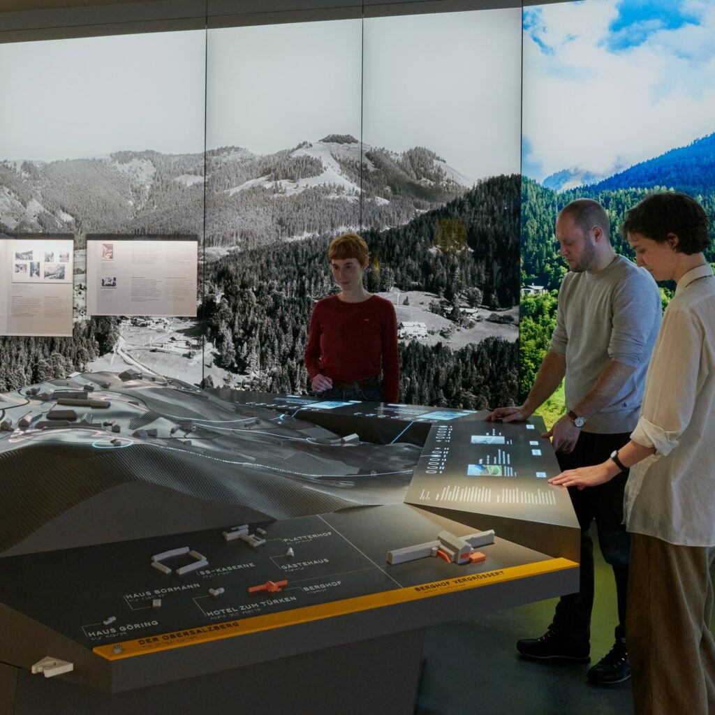 Personen am topografischen Modell des historischen Obersalzbergs
