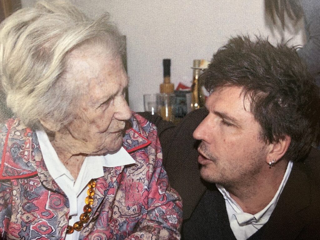 Links eine ältere Frau, rechts ein jüngerer Mann. Oma und Enkel.
